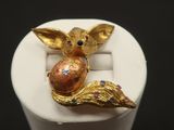 an image of a ring with a gold colored animal sitting on top of a white ring holder
