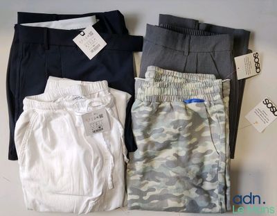 Trois paires de pantalons pour homme sont disposées sur une table.