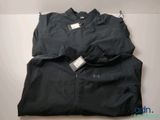 une veste noire avec une étiquette, posée sur une table