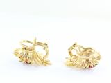 pair of gold earrings with red and green stones on them