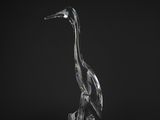 a clear glass bird sitting on top of a black surface