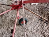 un tracteur rouge garé sur la terre battue
