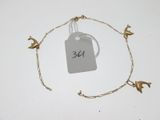 a gold bracelet with birds on it and a price tag attached to it