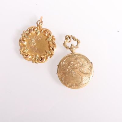 two gold coin pendants on a white surface with a white background