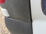 a close up of a car ' s rear bumper with a dog on it ' s side