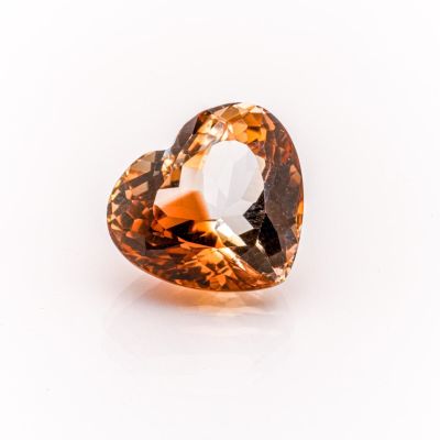 an orange diamond on a white surface with a white background