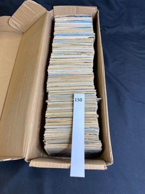 an open cardboard box filled with lots of books on a blue surface