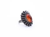 a silver ring with an orange stone in the center
