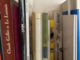 many books that are on a wooden shelf