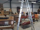 a large room with a ladder and a piano in it