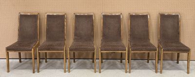 Quatre chaises sont alignées contre un mur dans une pièce