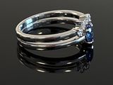 an image of a blue sapphire and diamond ring on a black surface