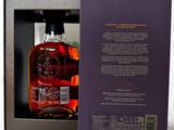 an open box with a bottle of whisky in it on a table