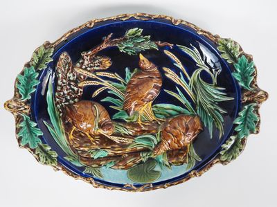 une assiette bleue sur laquelle sont représentés un oiseau et deux animaux