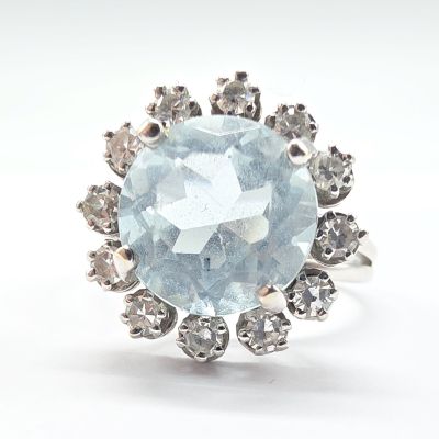 une image représentant une bague ornée d'une topaze bleue entourée de diamants blancs