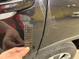 someone is measuring the height of a car ' s tire with a ruler