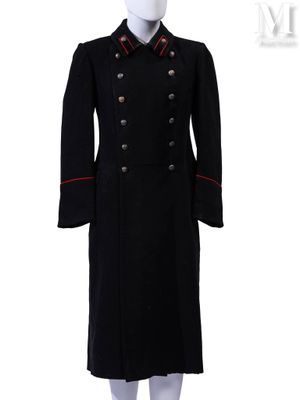 un manteau noir avec des bordures et des boutons rouges, présenté sur un mannequin