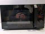 a man taking a picture of himself in the reflection of a microwave