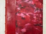 un gros plan d'un livre rouge posé sur une surface blanche