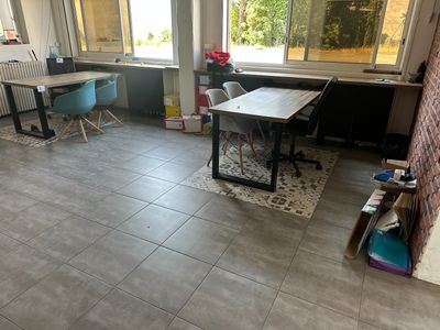 une pièce avec un bureau, des chaises et une fenêtre