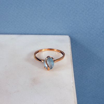 une image représentant une bague en or sertie d'une topaze bleue