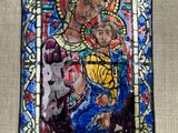 un tableau représentant une femme tenant un enfant dans ses bras, encadré d'un vitrail