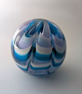 une boule en marbre bleu et blanc posée sur une surface blanche