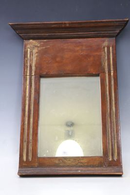 a small mirror hanging on the wall above a lamp