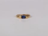 a close up of a gold ring with a blue sapphire stone