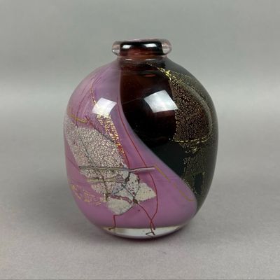 a purple vase with a black and gold design on it