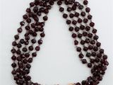 un gros plan d'un collier orné de perles sur un fond blanc