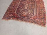 rug on the floor in the middle of a room with a chair