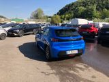 a blue car parked in a parking lot next to other cars