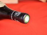 a bottle of wine sitting on a red cloth