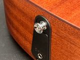 a close up of a wooden guitar with a key on it