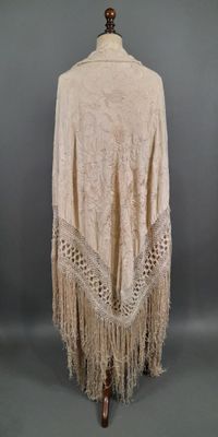un châle blanc à franges sur un mannequin