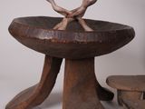 a wooden bowl with two birds on it and a bench