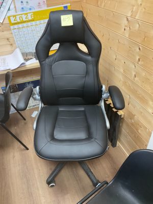 une chaise de bureau noire sur laquelle est collé un autocollant jaune