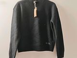 the sweater is hanging on a hanger on the wall