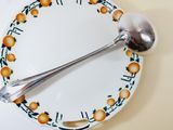 a plate with a spoon and a plate with oranges on it