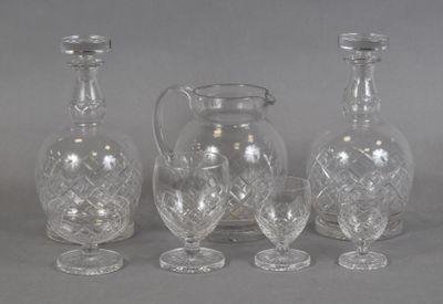 three clear glass vases and a pitcher on a gray surface