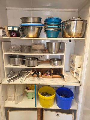 de nombreuses casseroles et poêles sur les étagères de la cuisine