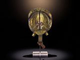 une image représentant un casque doré posé sur un socle