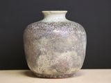 a vase that is sitting on a table with a black background