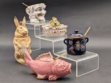 trois figurines en céramique représentant des animaux et un poisson, exposées