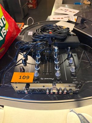 une table sur laquelle sont posés tout un tas d'appareils électroniques et un paquet de chips