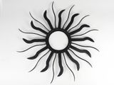 a black and white picture of a sun clock on the wall