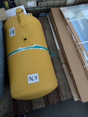 un grand réservoir jaune posé sur une palette, à côté d'autres cartons