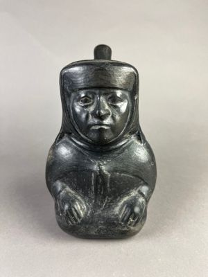 Vase représentant un dignitaire assis, les mains posées sur …