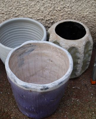 two large pots sitting next to each other on the ground